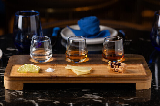 a wooden tray with glasses and food on it