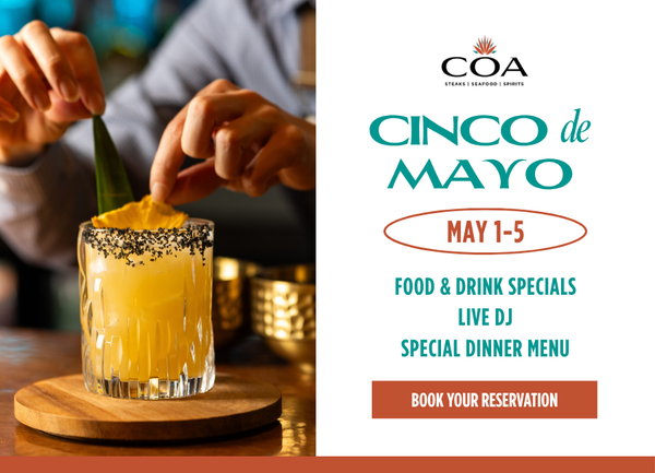 a person adding a slice of orange to a drink